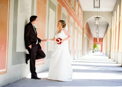 Brautpaar im Hofgarten Muenchen. Hochzeitsfotografie mit Blick in den Laubengang, romantische Szene bei Sonnenschein.
