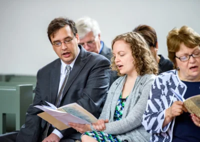 Menschen singen in einer Kirche bei einer Hochzeit in Ansbach, Teil einer Hochzeitsreportage.