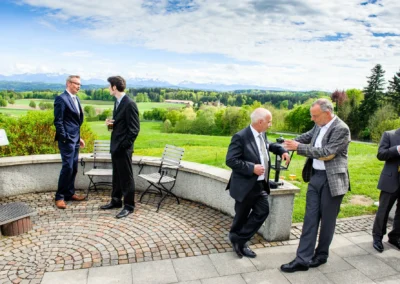 Hochzeitsfoto: Personengruppe in Anzug bei Fest im Freien, Aschbacher Hof, grüne Landschaft.