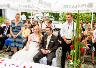 Brautpaar bei freier Trauung, umgeben von Gaesten in Röhrmoos bei Dachau, Hochzeitsfotografie.