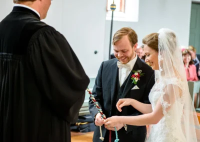 Brautpaar laechelt bei kirchlicher Trauung in Ansbach. Hochzeitsreportage zeigt emotionale Momente der Zeremonie.