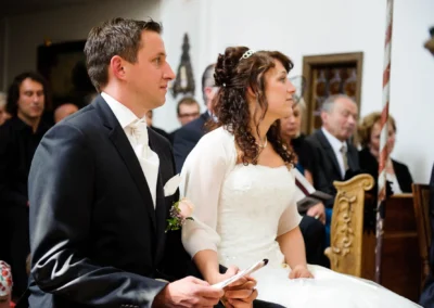 Brautpaar sitzt bei der kirchlichen Trauung im Schloss Aufhausen, Hochzeitsreportage in Oberbayern.