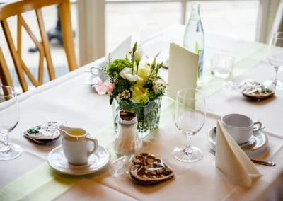 Elegante Hochzeitstafel mit Blumenstrauss und Geschirr in Feldkirchen-Westerham. Hochzeitsfotografie im Aschbacher Hof.