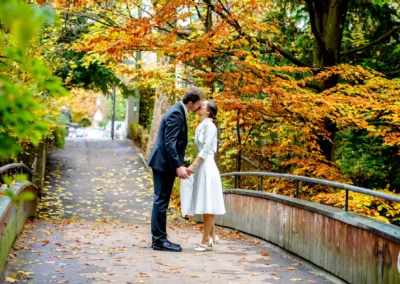 Brautpaar auf einer Bruecke im Herbstwald, Hochzeitsfoto im Englischen Garten in Muenchen.