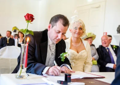 Standesamtliche Trauung in Bad Toelz, Brautpaar beim Unterschreiben der Dokumente, Hochzeitsfotografie Oberbayern.