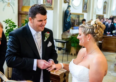 Bräutigam steckt der Braut in Wallfahrtskirche Wilparting den Ring an. Hochzeitsfotografie im Kreis Miesbach.