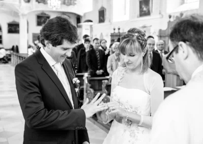 Brautpaar tauscht Ringe waehrend kirchlicher Trauung. Hochzeitsreportage in Neuburg an der Donau.