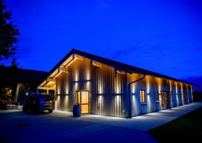 Abendaufnahme einer beleuchteten Holzscheune bei einer Hochzeitsfeier in Otterfing, suedlich von Muenchen.