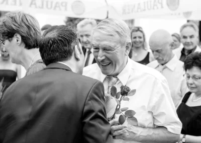 Lachender Mann mit Rose bei Hochzeit in Röhrmoos, Reportage von Hochzeitsfotografie, Landgasthof Brummer.