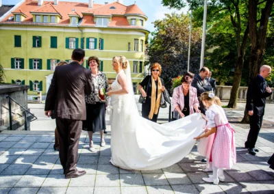 Braut in muenchen schwabing mit Gaesten und Blumenkindern bei kirchlicher Trauung im Freien. Hochzeitsfotograf.