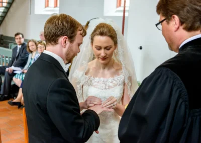 Braut und Bräutigam tauschen Ringe in einer Kirche in Ansbach während der Hochzeitszeremonie.