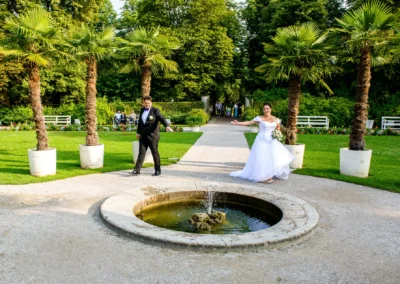 Brautpaar tanzt im Garten von Schloss Nymphenburg neben Springbrunnen, Hochzeitsfotografie in Muenchen.