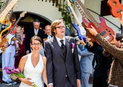Brautpaar lacht nach kirchlicher Trauung, umgeben von Gitarren, bei Hochzeit nördlich von München. Hochzeitsfotografie.
