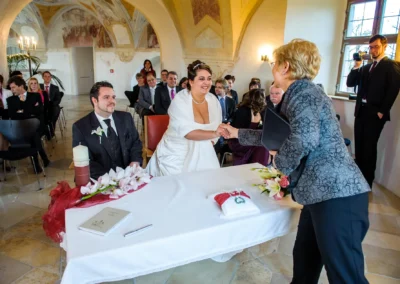 Brautpaar bei standesamtlicher Trauung im Schloss Hoechstaedt, nahe Dillingen, mit Gratulation und Gaesten im Hintergrund.