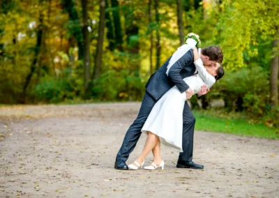 Brautpaar-Kuss im Herbstwald, Hochzeitsfoto im englischen Garten Muenchen, romantisch und natuerlich.