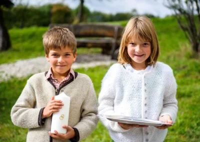 Zwei Kinder halten Kerze und Tablett bei Hochzeitsreportage am Starnberger See.