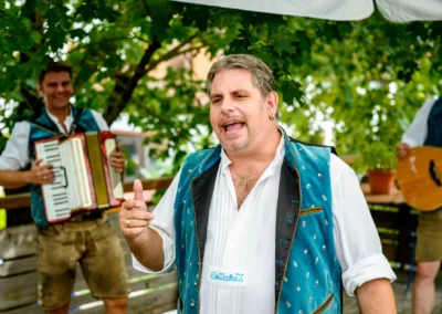 Mann in traditioneller Tracht singt, begleitet von Akkordeon und Gitarre, bei einer Hochzeit in Rohrmoos.