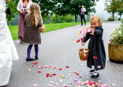 Zwei Maedchen streuen Blumen bei kirchlicher Trauung einer Hochzeit in der Naehe von Irschenberg. Hochzeitsfoto.