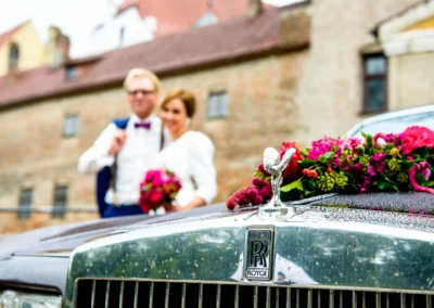 Hochzeitsfoto bei der Burg Trausnitz mit Brautpaar und verzierten Auto in Szene gesetzt.