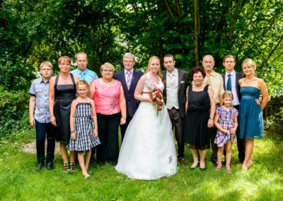 Hochzeitsfoto mit Brautpaar und 12 Gaesten im Garten in Roehrmoos bei Dachau.