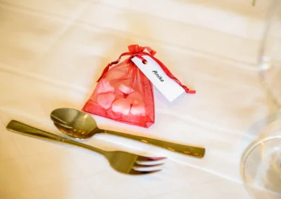 Rotes Geschenkset am Hochzeitstisch mit Löffel und Gabel im Landgasthof Brummer, Hochzeitsfotografie.