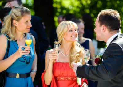 Gaste bei Hochzeitsfeier im Freien mit Sektgläsern, aufgenommen in landkreis starnberg. Hochzeitsfotografie in Aktion.