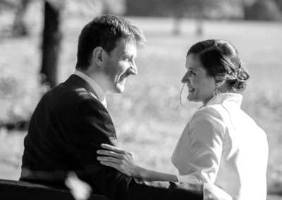 Brautpaar in innigem Moment auf einer Bank im Englischen Garten fotografiert, stimmungsvolles Hochzeitsfoto in Muenchen.