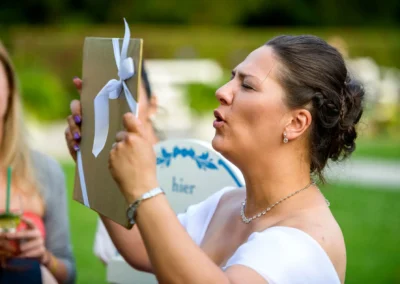 Person haelt Geschenk mit Schleife bei Hochzeit in Schloss Nymphenburg. Hochzeitsreportage in Muenchen.