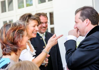 Lachende Hochzeitsgesellschaft bei Hochzeitsfeier im Kurhaus Bad Toelz, festliche Stimmung und Freude.