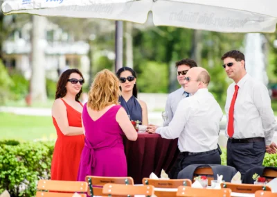 Gruppengespräch bei einer Hochzeit im Freien unter einem Sonnenschirm, Kurhaus Bad Toelz, Hochzeitsfoto.