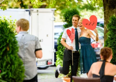 Paar mit Herz-Requisiten bei einer Hochzeit, aufgenommen im Dachauer Hinterland. Hochzeitsfotograf dokumentiert den Moment.