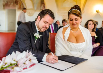 Bräutigam und Braut unterschreiben bei standesamtlicher Trauung im Schloss Höchstädt an der Donau, Hochzeitsfotografie.