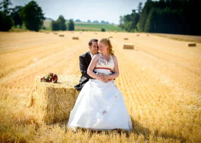 Brautpaar auf Strohballen in Feld bei Röhrmoos, Hochzeitsfoto von Hochzeitsreportage nördlich von München.