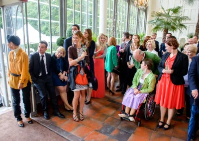 Hochzeitsgesellschaft im Palmenhaus Schloss Nymphenburg, Gäste in eleganter Kleidung, Hochzeitsfotografie.