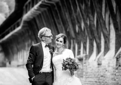 Brautpaar-Portrait bei Hochzeit auf Burg Trausnitz, Mann im Anzug, Frau im Hochzeitskleid mit Blumenstrauss.