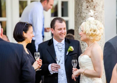 Hochzeitsreportage in Bad Toelz: Brautpaar und Gaeste lachen und sprechen bei einer Hochzeit.