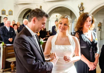 Brautpaar tauscht Ringe in der Kirche bei einer Hochzeit in Sankt Sylvester, Muenchen. Hochzeitsreportage.
