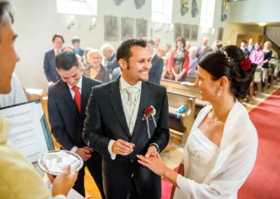 Brautpaar tauscht Ringe bei kirchlicher Trauung in München Pasing, festgehalten von Hochzeitsfotograf.