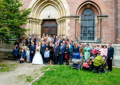 Hochzeitsgesellschaft vor Kirche in Muenchen-Lehel. Aufnahme einer Hochzeitsreportage mit Brautpaar und Gaesten.