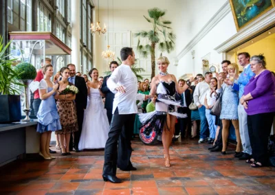 Tanzpaar vor applaudierender Hochzeitsgesellschaft im Palmenhaus Schloss Nymphenburg, Hochzeitsfotograf aus Muenchen.