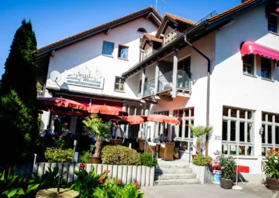 Aussenansicht Hotel Seehof Wessling mit Terrasse, Sitzgelegenheiten und Sonnenschirmen, ideal fuer Hochzeitsreportage.