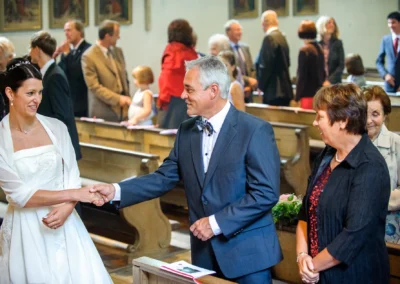 Brautpaar laechelt waehrend der kirchlichen Trauung in einer Kirche in Muenchen Pasing. Hochzeitsfotografie.