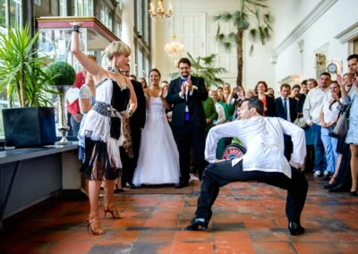Tanzvorführung bei Hochzeit im Palmenhaus Schloss Nymphenburg. Gäste schauen begeistert zu. Hochzeitsfotografie.