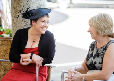 Zwei lachende Frauen unterhalten sich bei einer Hochzeitsfeier in Bad Toelz, festgehalten in einer Hochzeitsreportage.