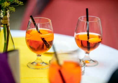 Orangene Getränke in Gläsern mit Strohhalmen auf Hochzeit bei Schloss Grünau. Hochzeitsfotograf aus München.