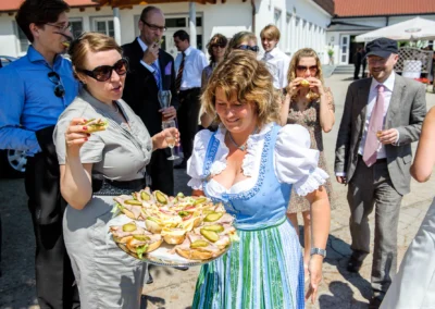 Hochzeitsgaeste geniessen Snacks im Freien bei einer Hochzeit in der Naehe von Dachau. Hochzeitsreportage.