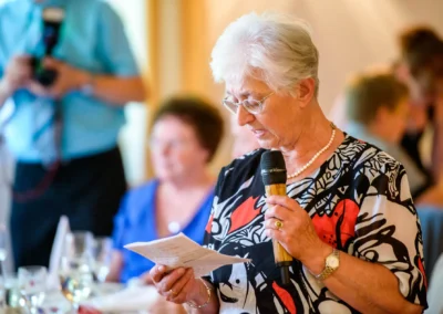 Ältere Frau haelt Rede bei Hochzeit in Roehrmoos. Hochzeitsreportage von Gespraechen und Emotionen.
