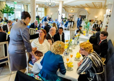 Gaste unterhalten sich an Hochzeitstischen im Bayerischen Hof Miesbach, Hochzeitsreportage zeigt lebendige Feier.