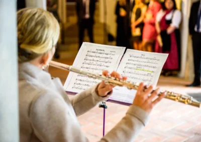 Flötistin spielt während der kirchlichen Trauung bei einer Hochzeit in Landshut. Hochzeitsreportage.