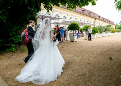 Brautpaar laeuft zur Hochzeitsfeier in der Orangerie Ansbach, Hochzeitsfotografie westlich von Nuernberg.